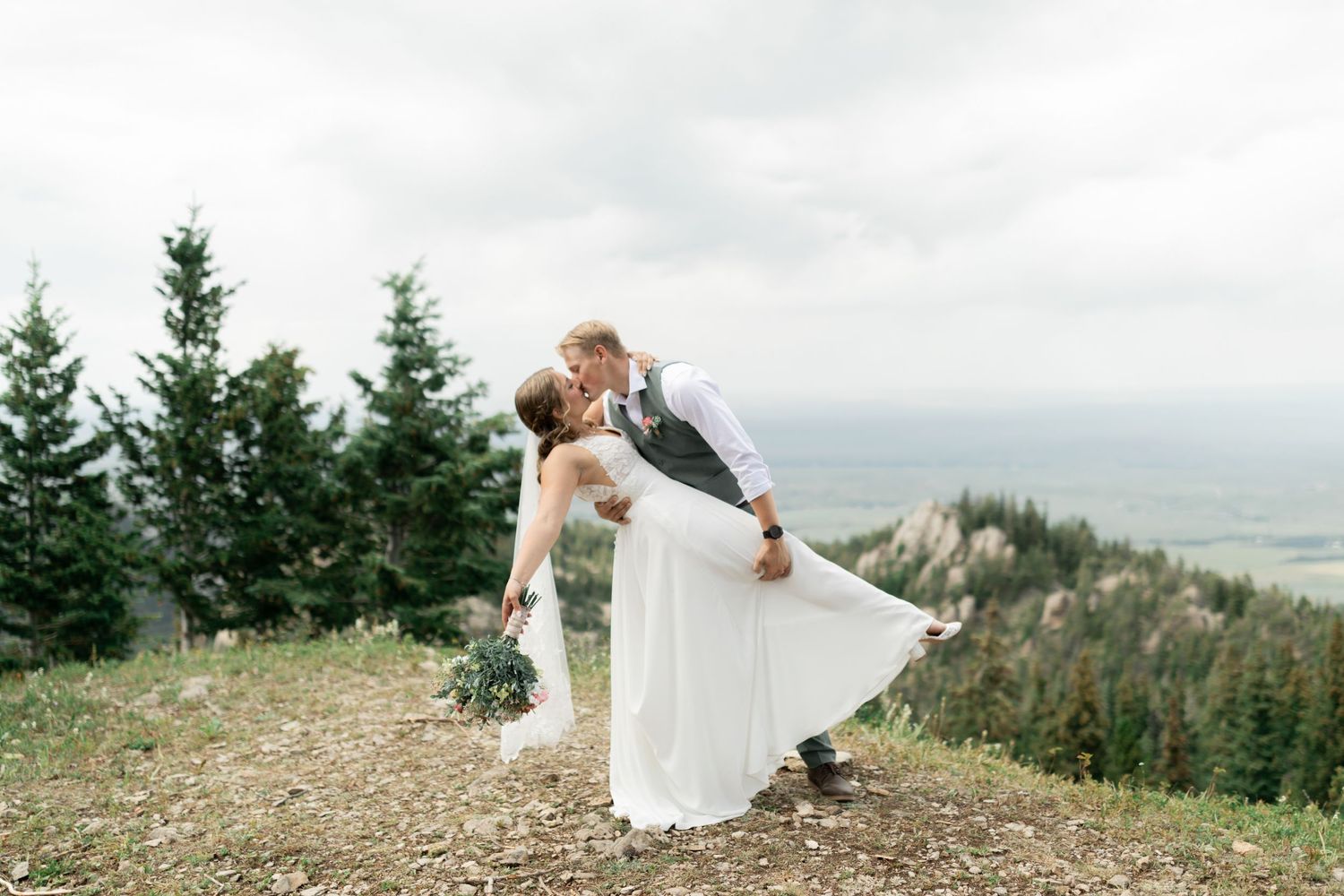 A couple kissing after their wedding ceremony on top of a Montana mountain.