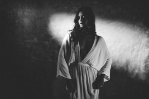 A dramatic black and white sequence showing a figure emerging from shadows with moody lighting effects.
