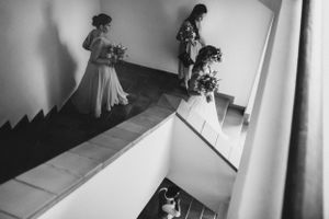 A black and white photo series showing a bride walking down stairs in a flowing wedding gown and veil.
Mexico wedding photographer