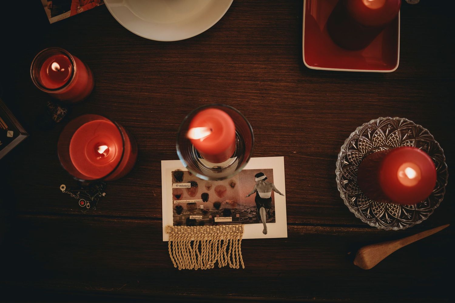 velas vermelhas acesas com um card sobre a mesa usada em ritual de circulo feminino em Portugal