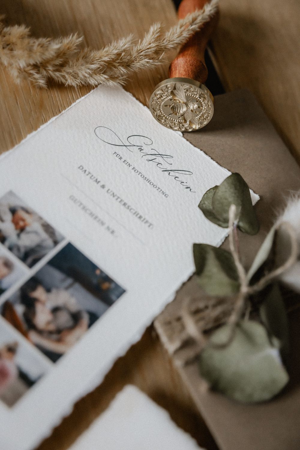 Wedding invitation cards with delicate details and photographs laid out on a wooden surface.
