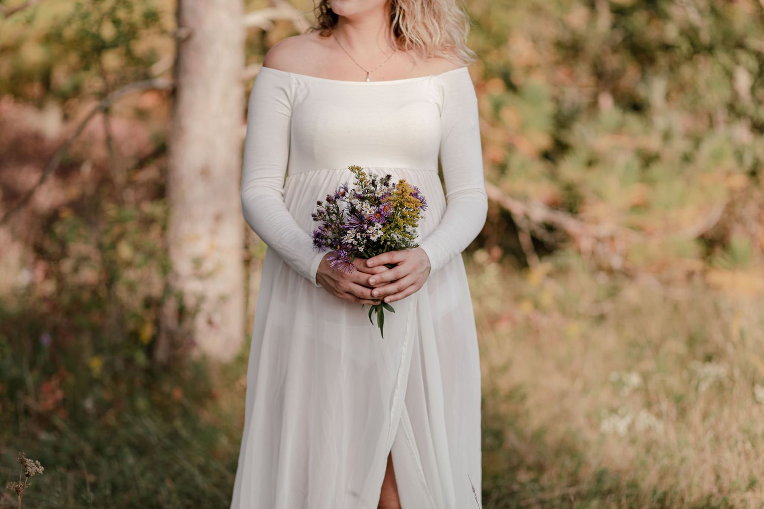 Detail shot of a wildflower bouquet in front of a pregnant belly in Kingston, Ontario, CA.