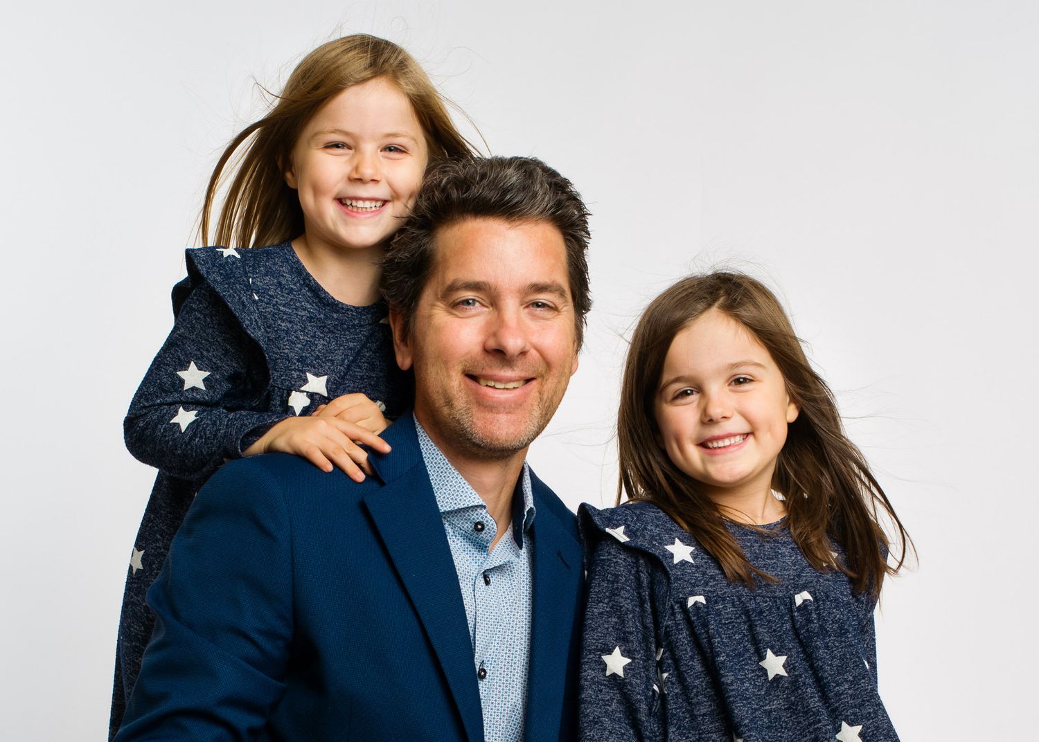 Selbstrportrait Walter Elsner Fotograf in Klagenfurt mit seiner Familie im Fotostudio, weisser Hintergrund, lachende Kinder.