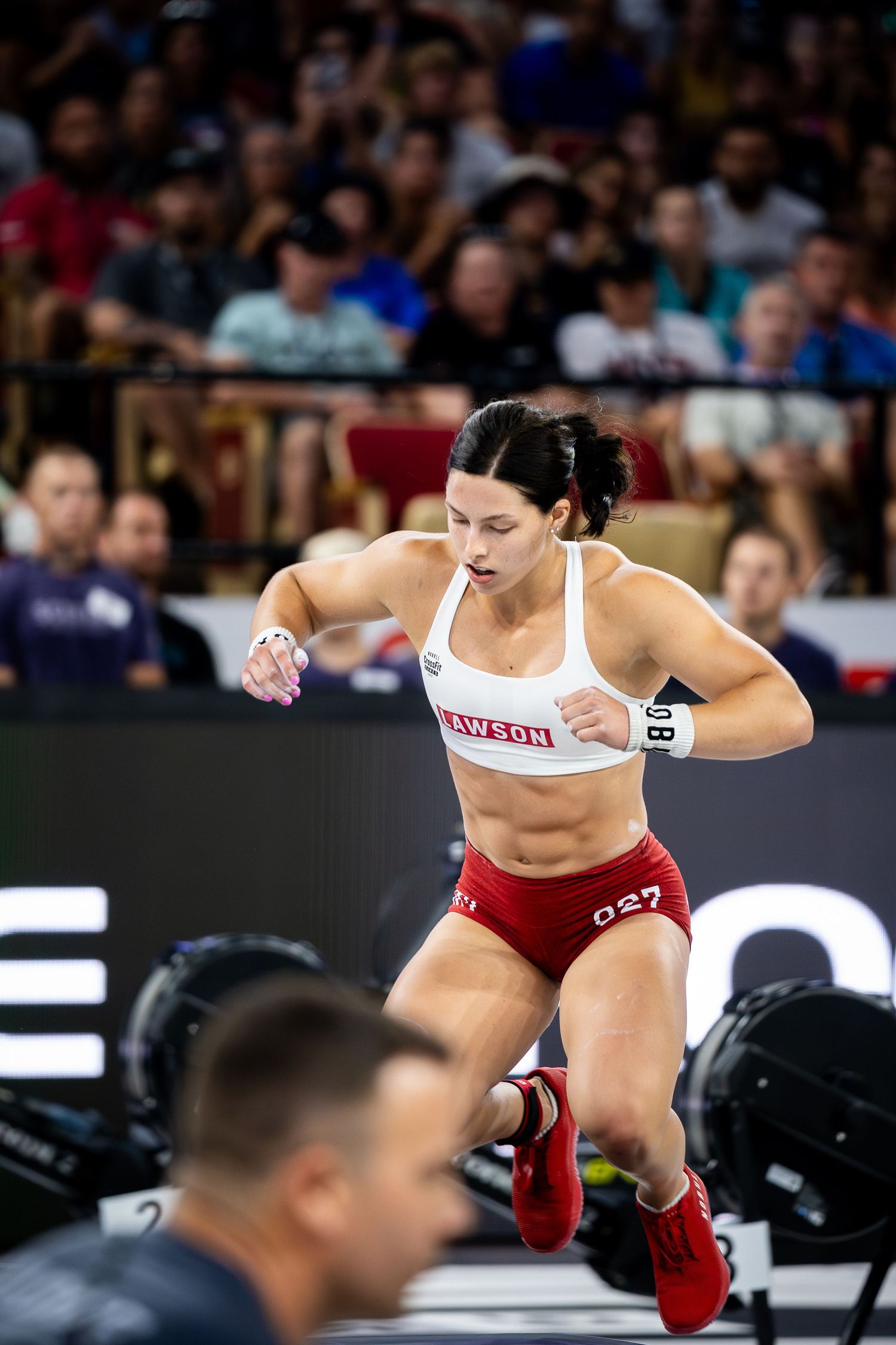 Emma Lawson in red shorts performing dynamic movement during competition.