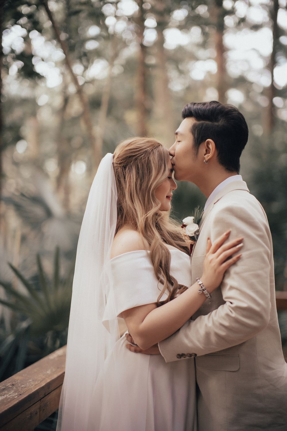 Romantic wedding moment captured against rustic brick wall background.