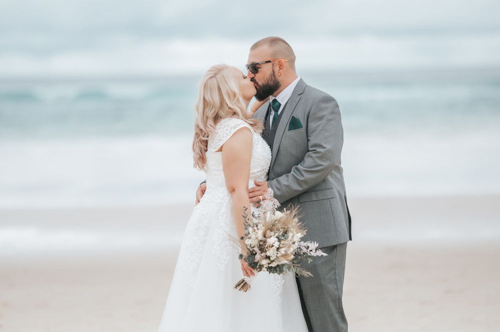Intimate wedding portrait captured in outdoor garden setting with soft lighting.