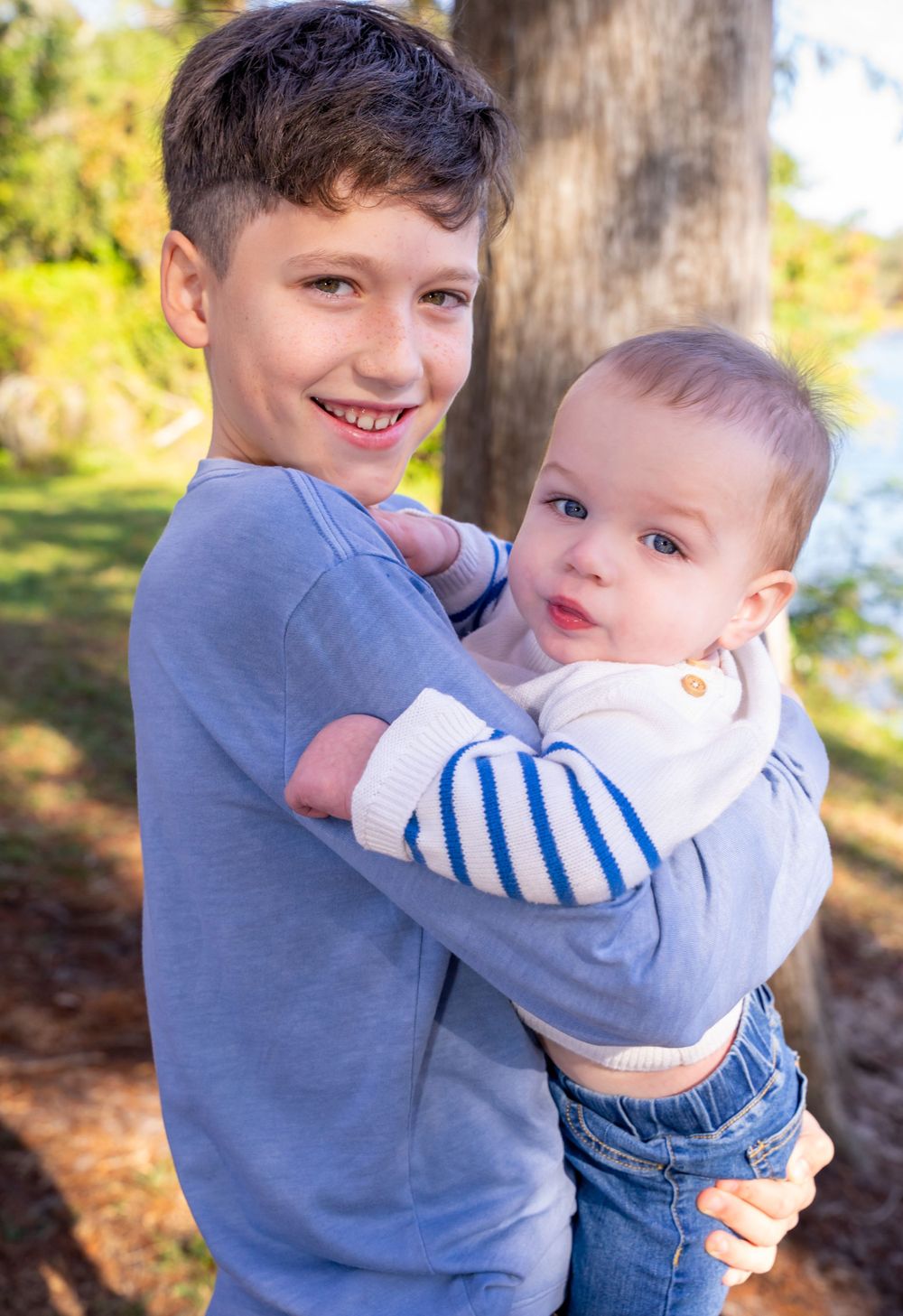 Two children sharing a sweet moment together outdoors in natural lighting.