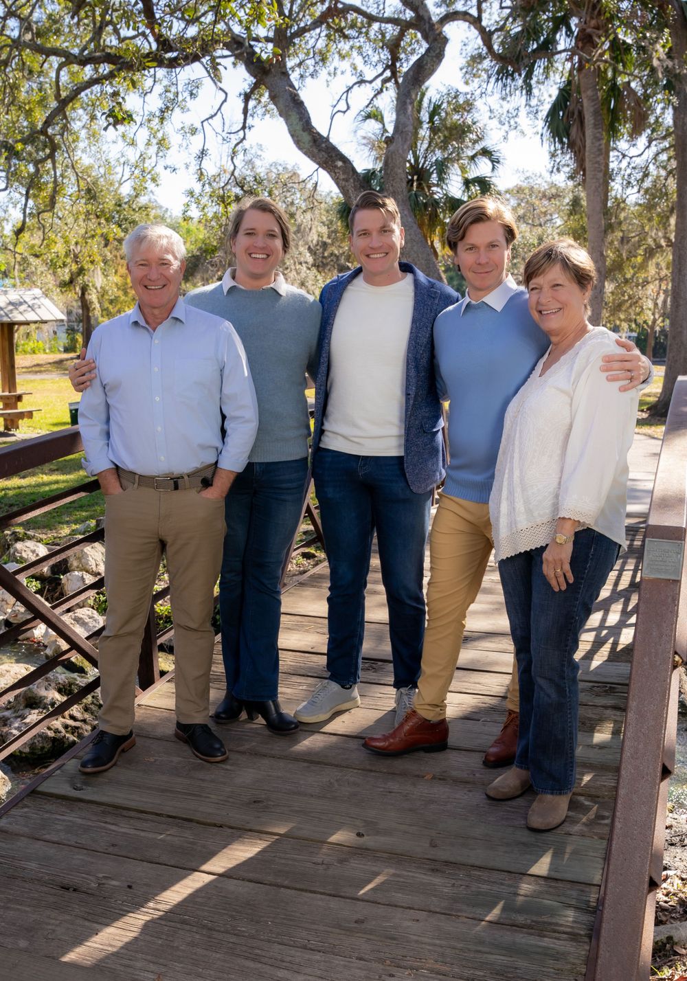 Group photo of family members sitting together on wooden deck.