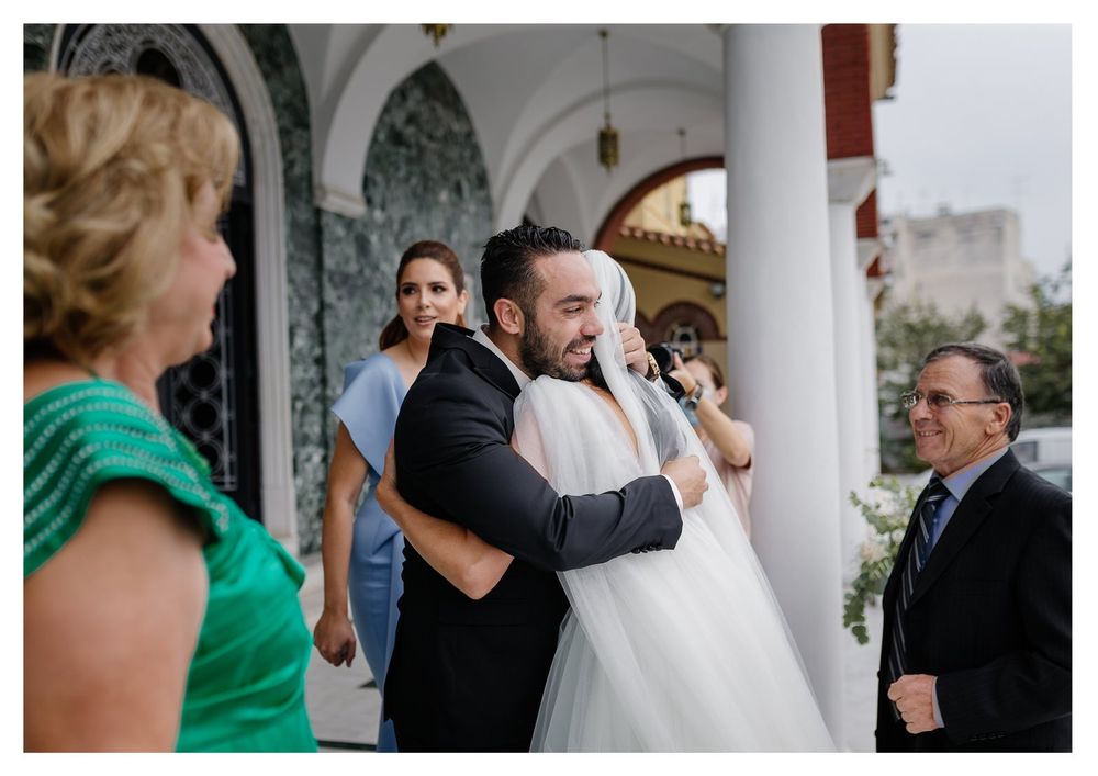 Emotional wedding ceremony moment under ornate church archway with white pillars.