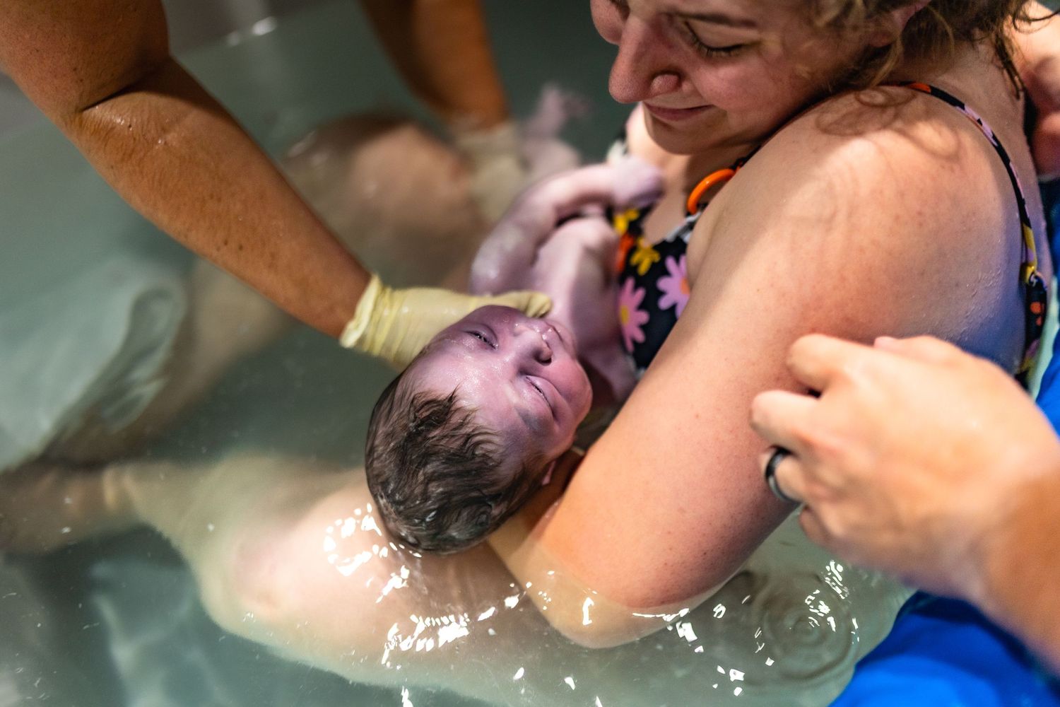 Water birth scene showing emotional support and care during delivery.