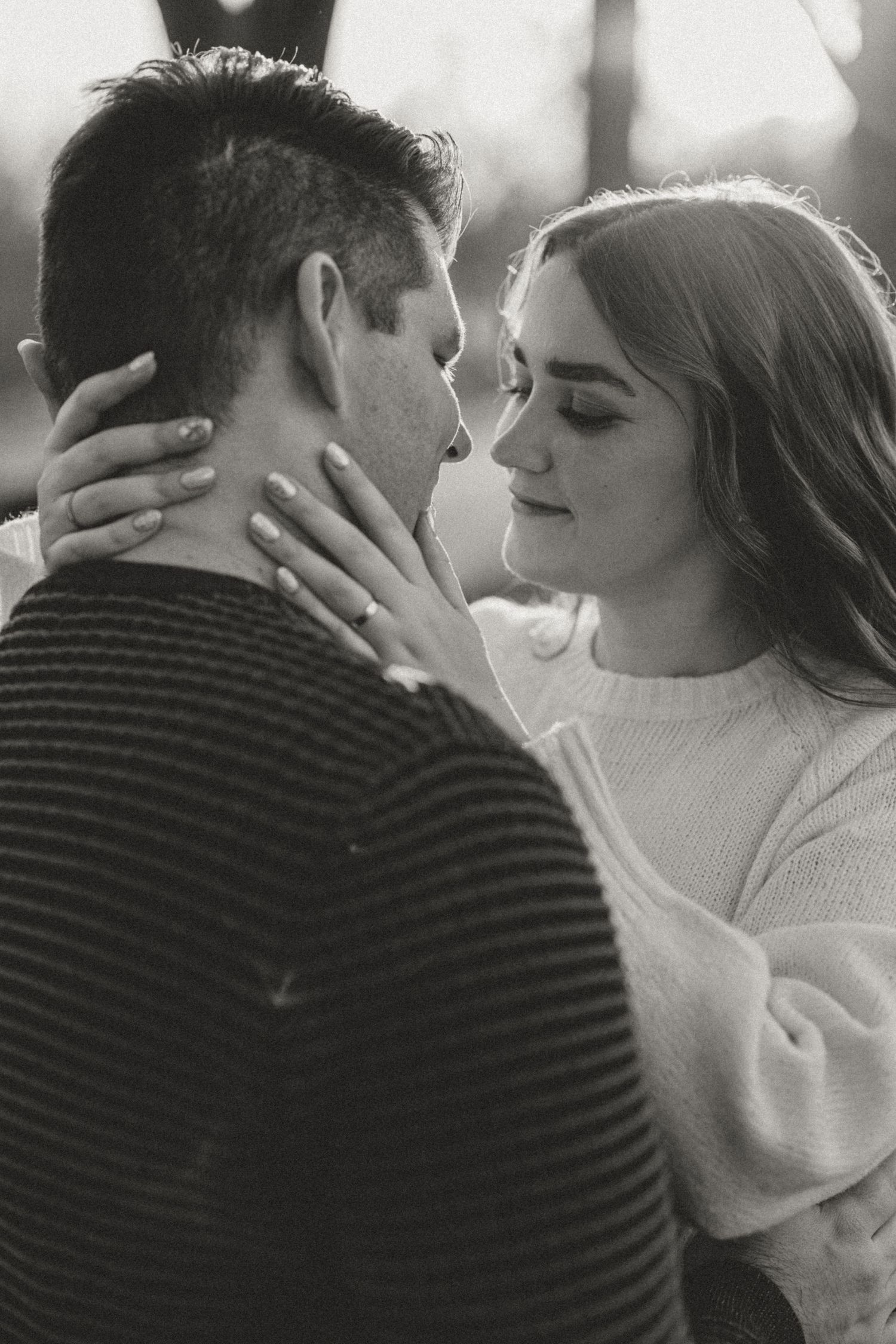 A romantic black and white photo of a couple in an intimate embrace with soft lighting.