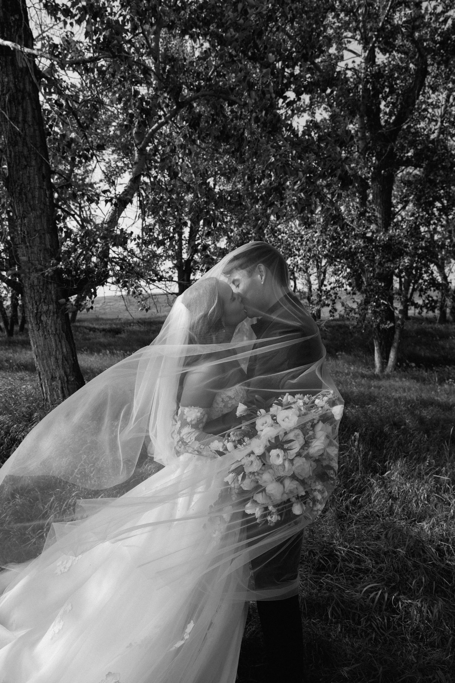 A romantic scene with a bride wearing a white dress and customized denim jacket against a dark background at night.