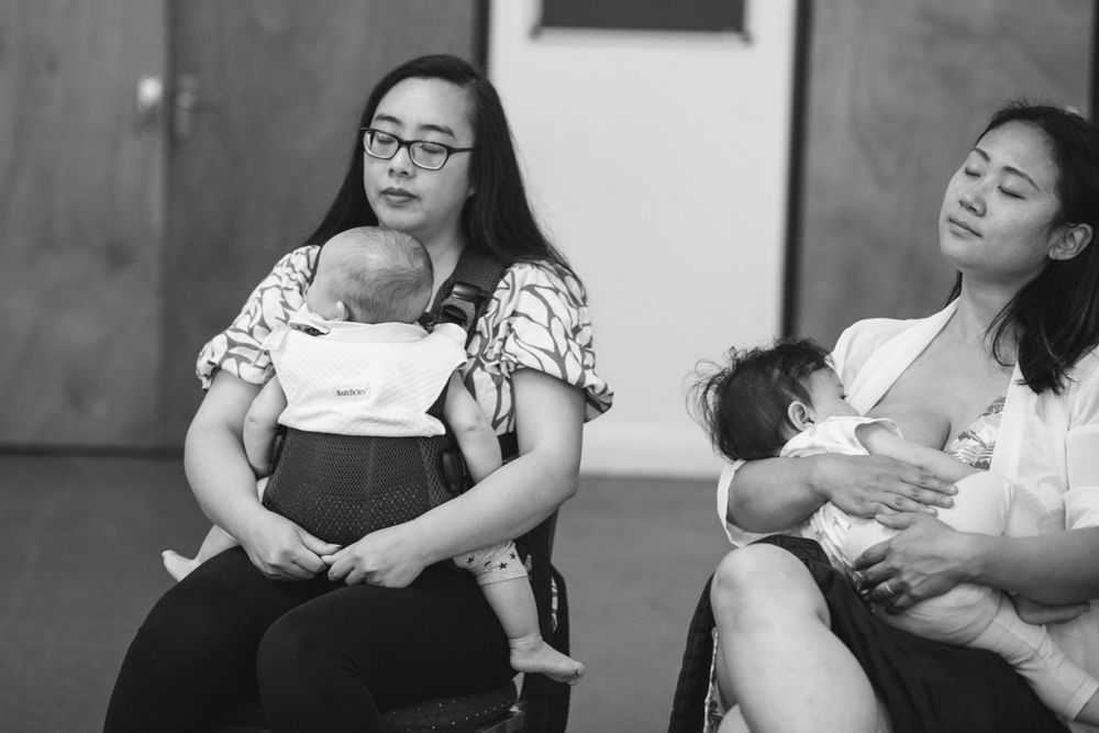 Parents and babies resting during exercise class in studio space.