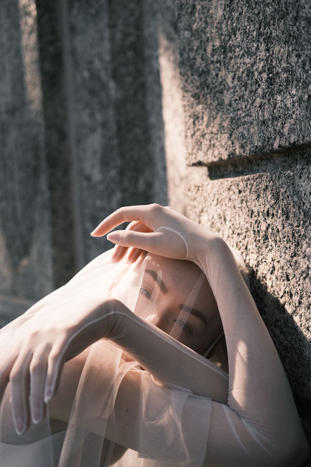 Bride’s veil and hands glowing in natural Italian light.