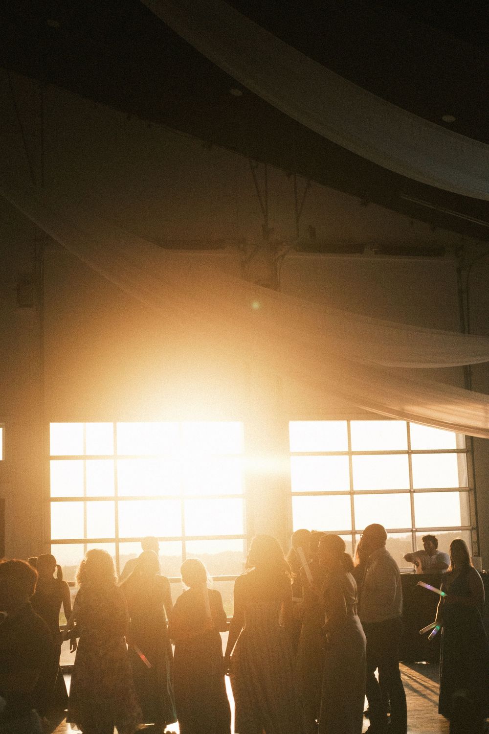 Golden-hour wedding guests silhouetted against Italian sunset.