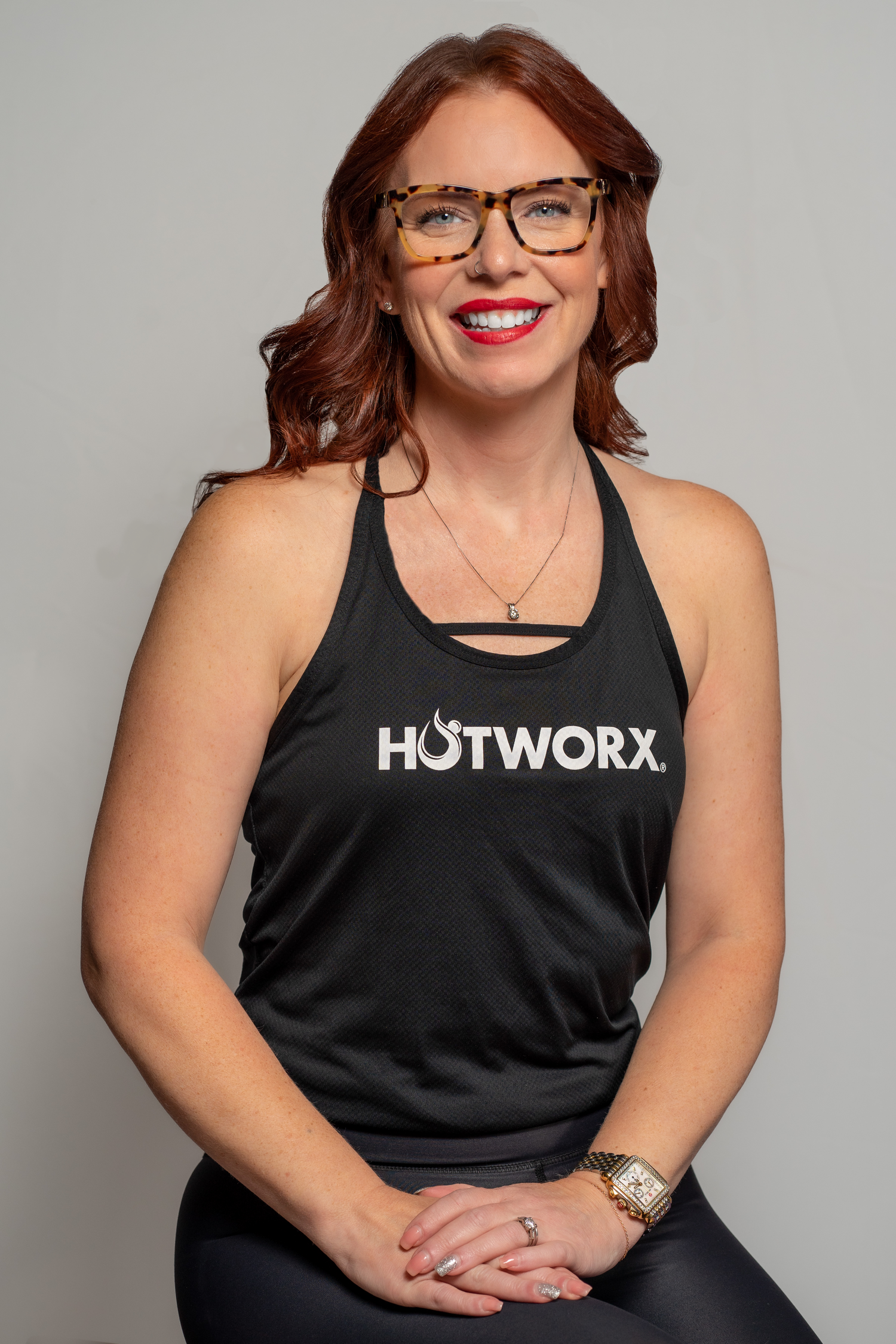 Professional portrait series of someone wearing a black tank top with text and glasses against a gray background.