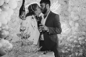 Bride and groom kissing behind a flowing champagne tower