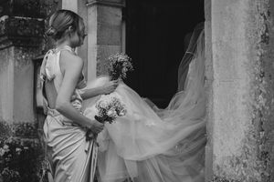 Romantic wedding moment captured against historic stone architecture.