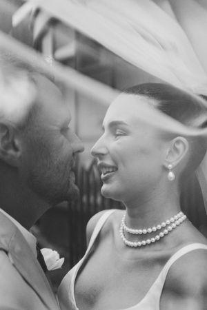 Elegant black and white portrait showing pearl necklace detail at a wedding.