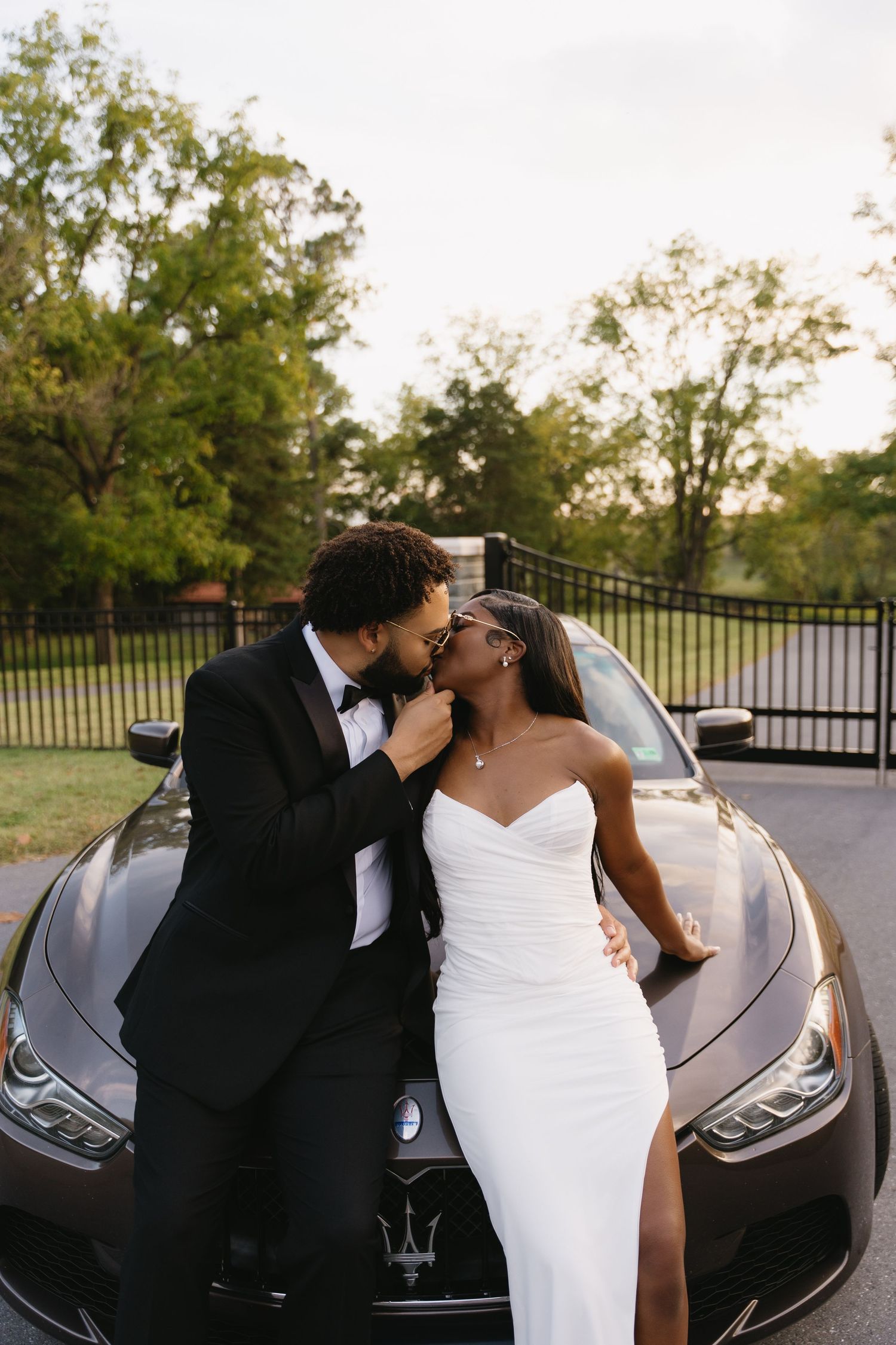 Romantic dip kiss between newlyweds in front of vineyard landscape.