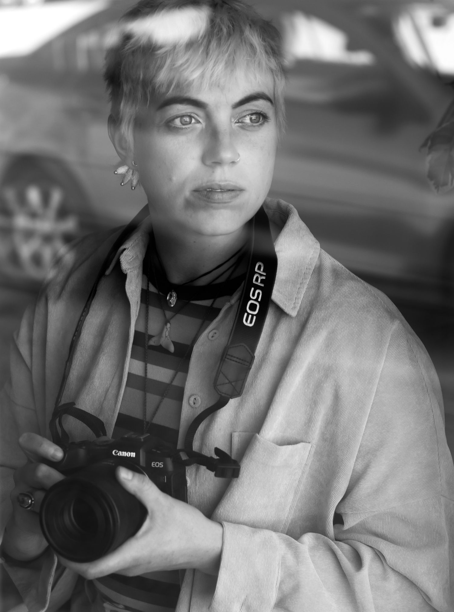 A black and white picture of a woman holding a camera. Her name is Caro.