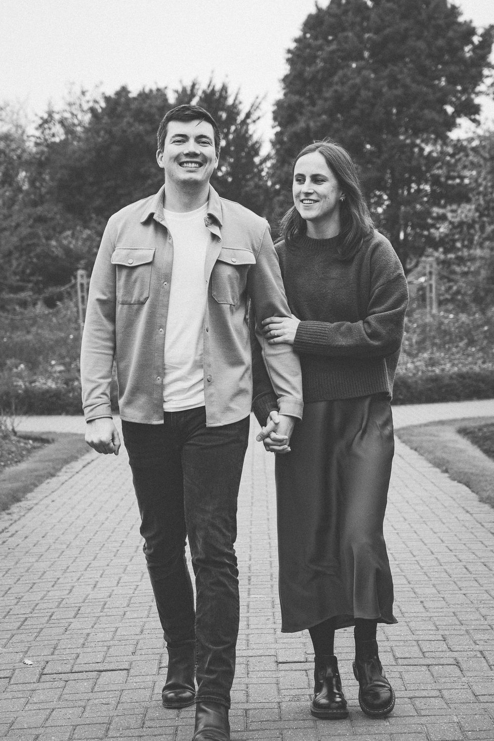 Lower body shot of a couple walking together on a stone pathway.
