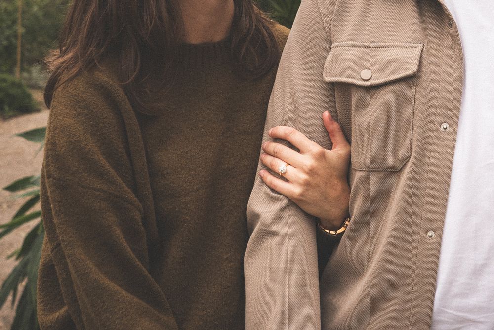 Intimate detail shots of a couple embracing in casual autumn attire.
