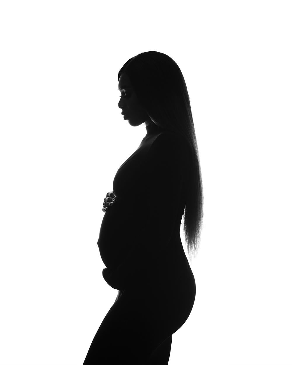 A silhouetted maternity profile portrait against a white background.