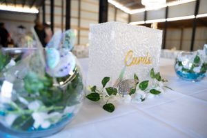 White roses and delicate butterflies create an elegant wedding reception table centerpiece.