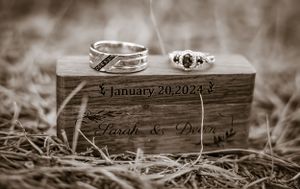 Wooden wedding ring box with engraved date January 20 2024 in sepia tone.
