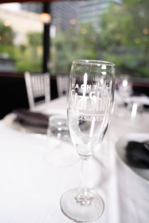 Engraved wine glasses on white tablecloth in restaurant setting.