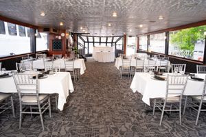 Wedding reception venue with white chairs and textured carpeting in elegant banquet hall.