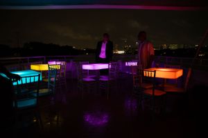 Nighttime building exterior illuminated with vibrant purple and orange LED lighting.