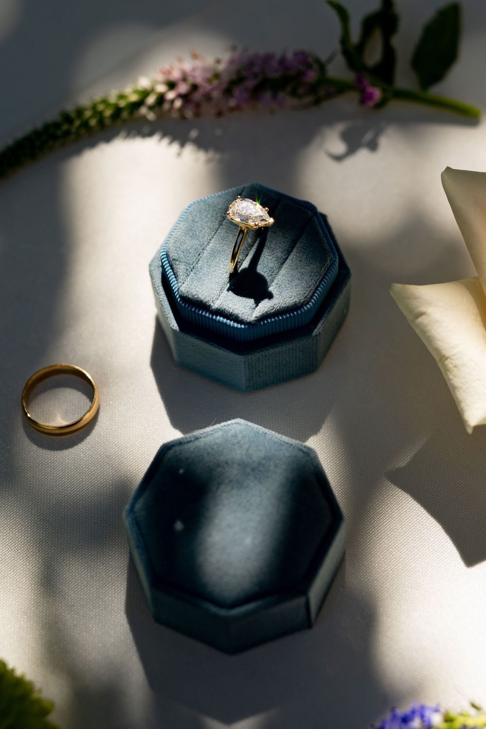 Wedding rings and jewelry boxes arranged artistically with dramatic lighting and shadows.