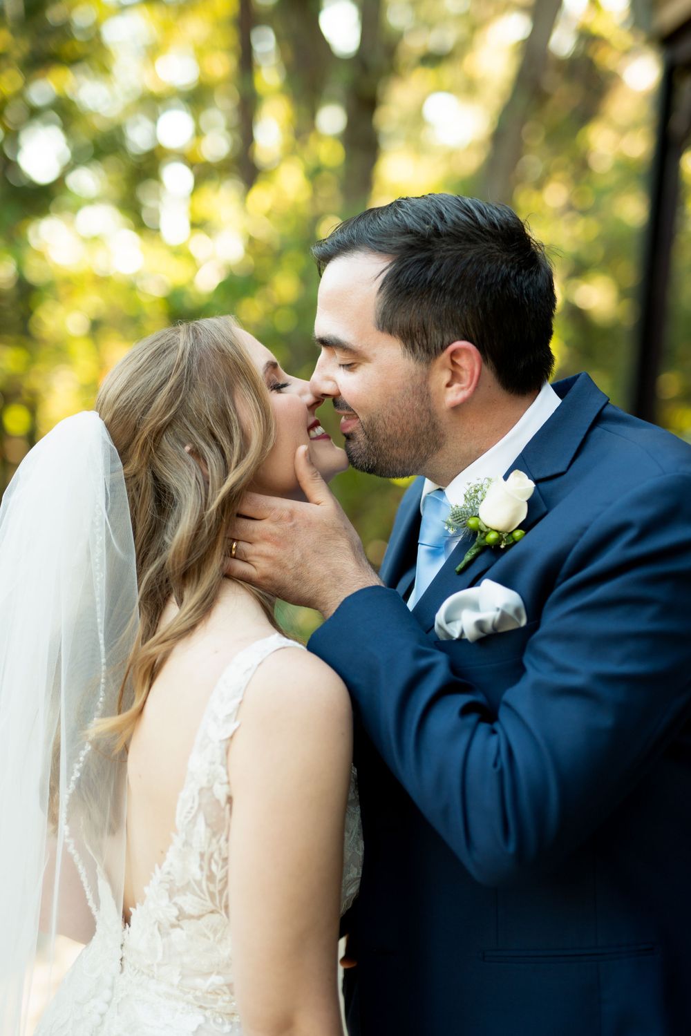 Intimate wedding portraits captured in golden sunlight among trees.