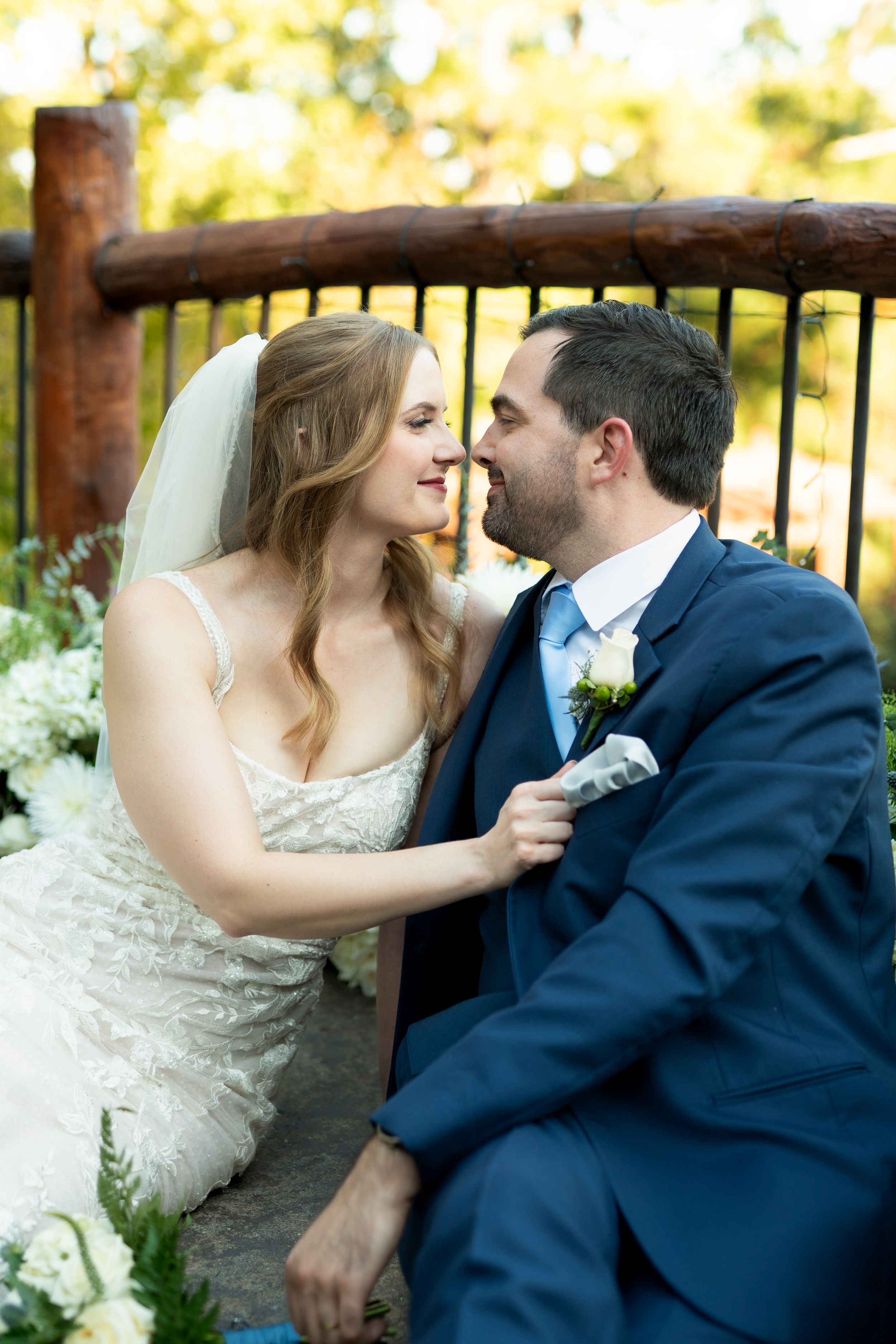A couple sharing intimate moments in formal wedding attire during an outdoor photo session.
