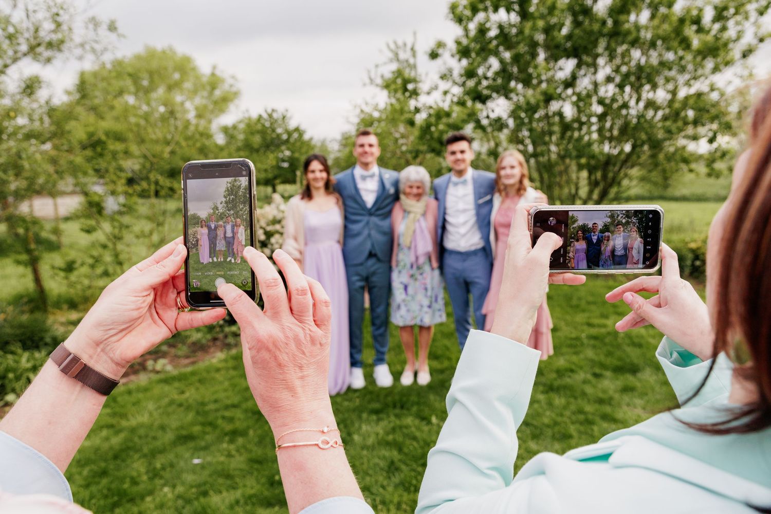 Wedding guests gather on a lush green lawn for an outdoor celebration.