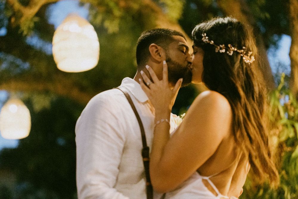 A romantic evening wedding moment captured with glowing lanterns in the background.
