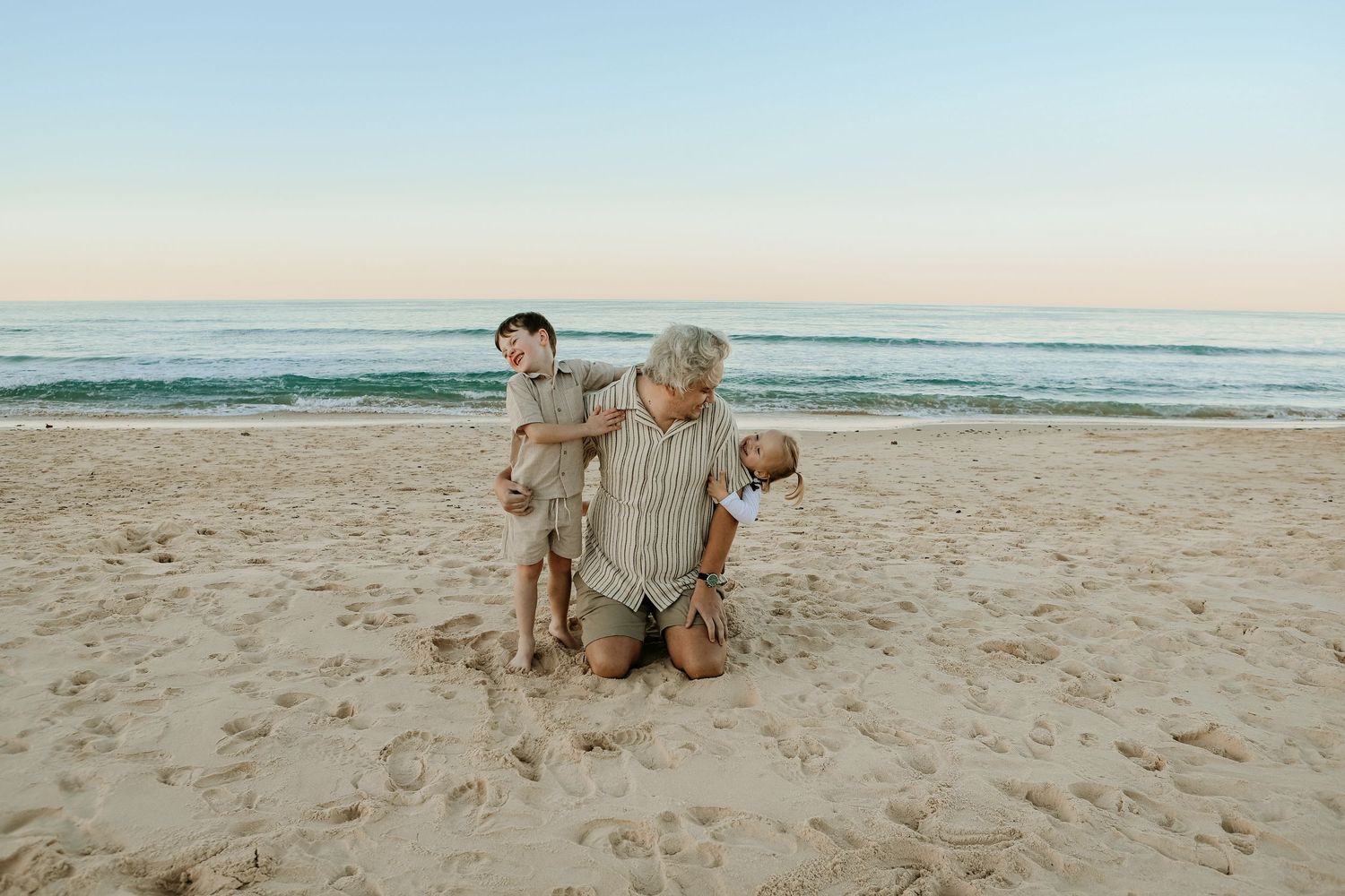 Uncle having fun with niece and nephew on beach