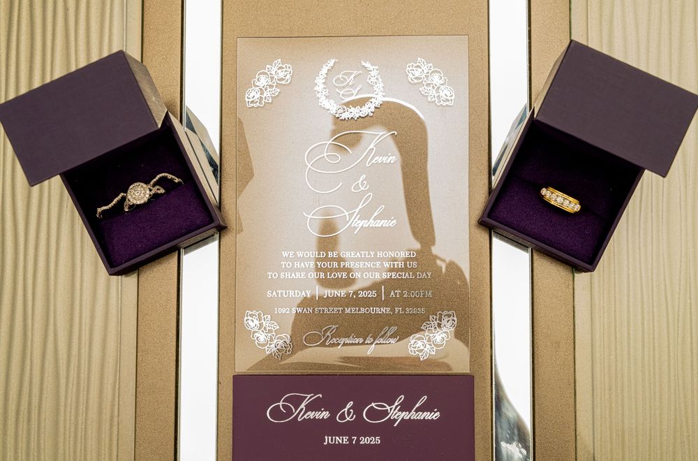 Wedding invitation and ring boxes featuring elegant gold and purple design elements.