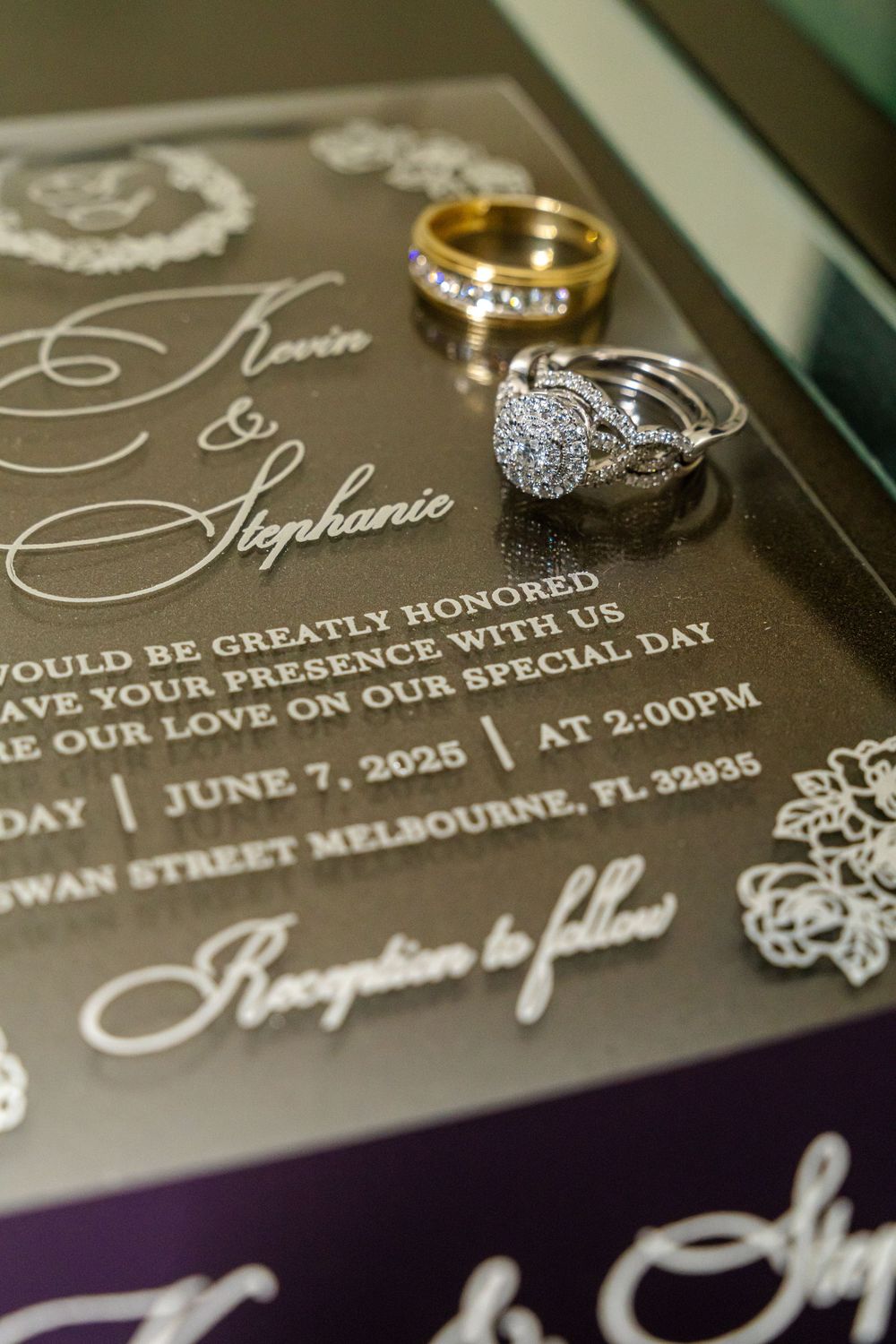 Wedding invitation with elegant calligraphy and two rings, including a diamond engagement ring and gold wedding band.