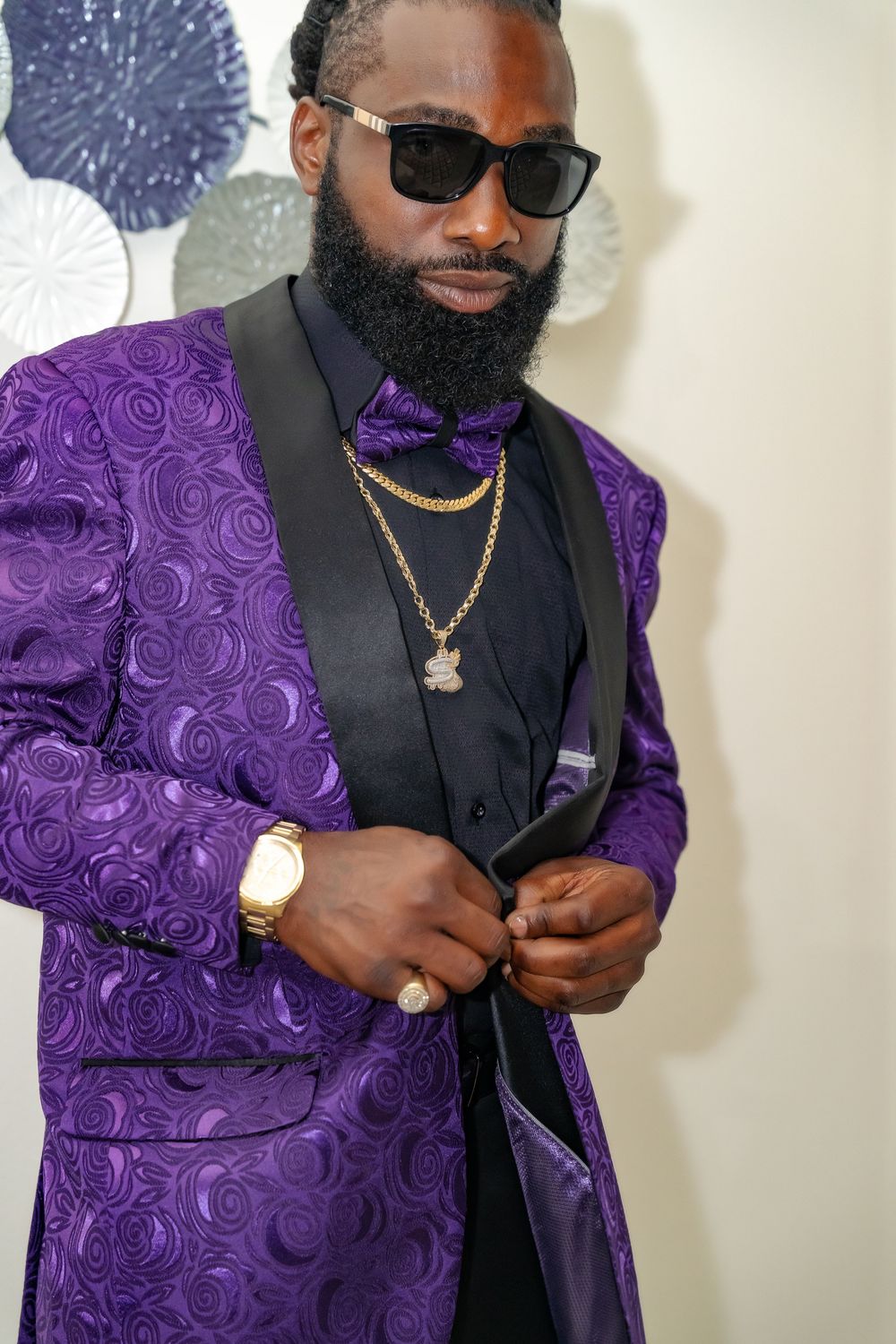Close-up details of a purple brocade vest with black lapels and gold accessories.