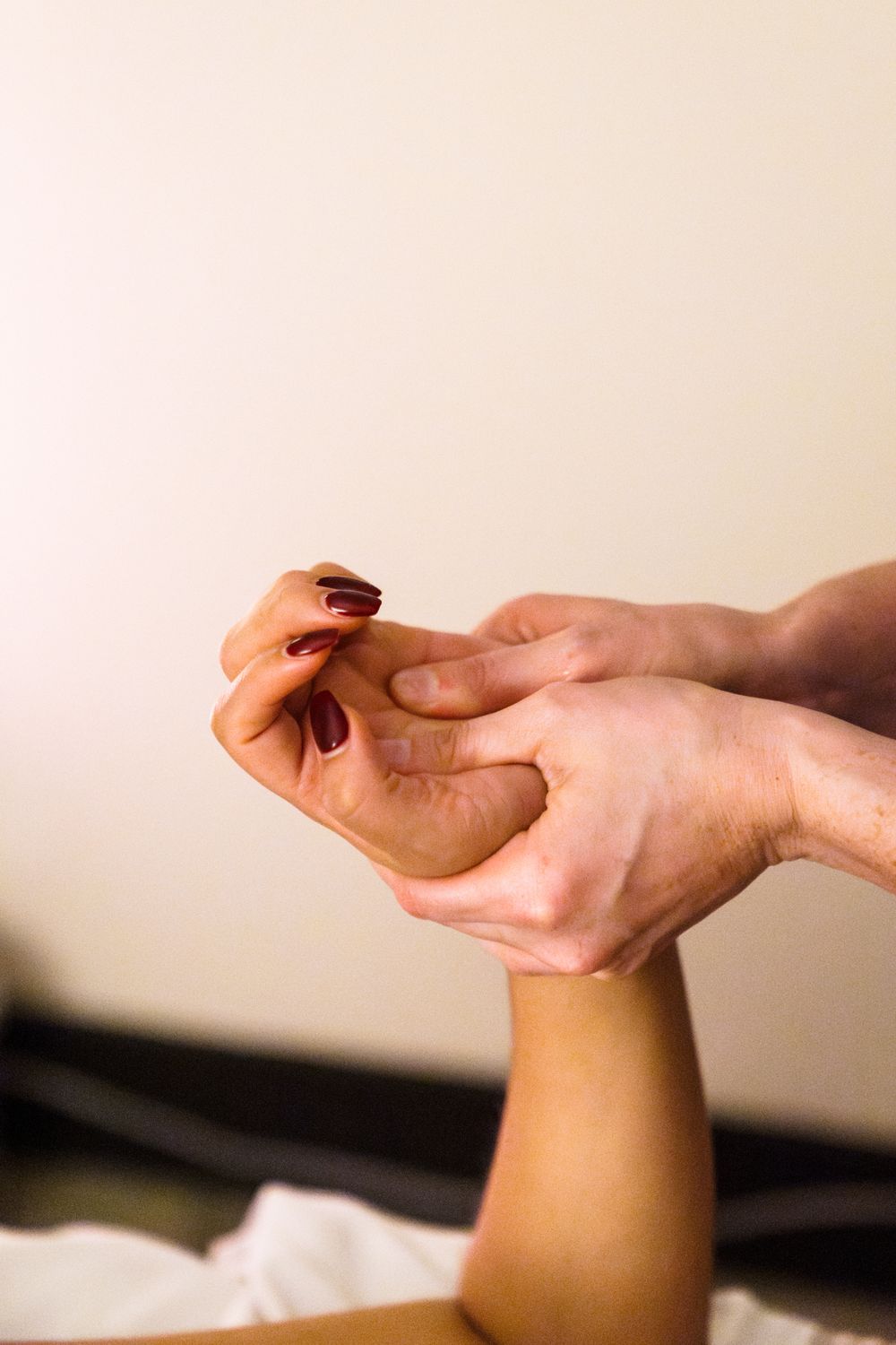 Massage therapist working on pressure points of client's hand and wrist.