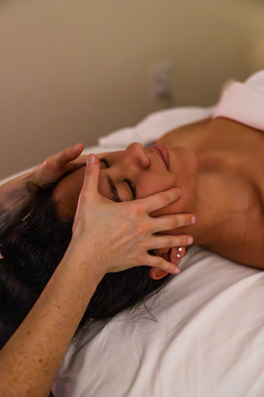 Therapeutic facial massage being performed in a professional spa setting.