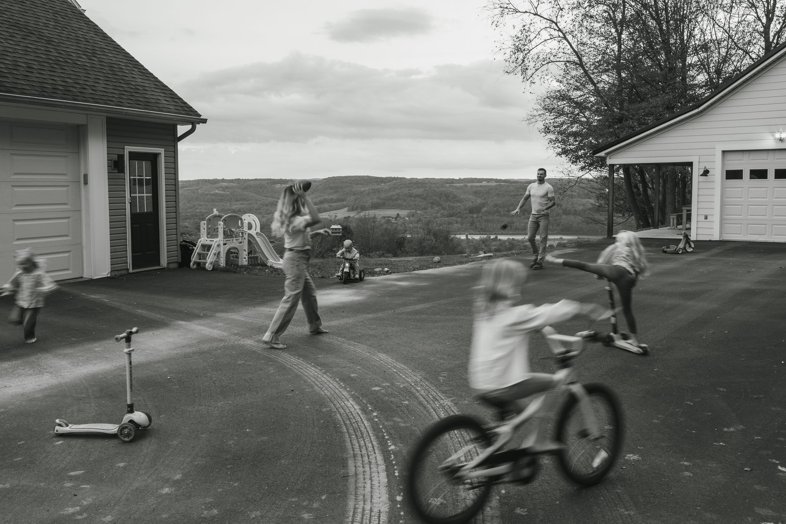 Vintage black and white photos show children playing and riding bikes on a suburban driveway near a house.