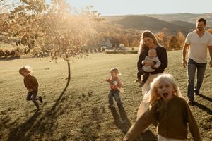 People walk together across a golden sunlit meadow at sunset while enjoying an outdoor adventure in nature.
