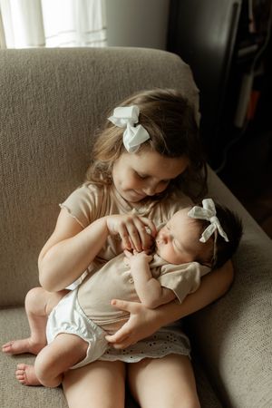 A tender moment captured in a series of black and white photos showing parent and child snuggling on a couch.