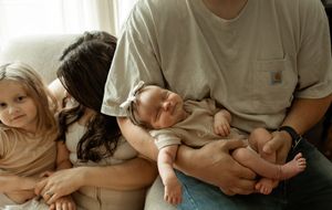 A series of connected images showing a parent breastfeeding a baby while resting on white bedding.