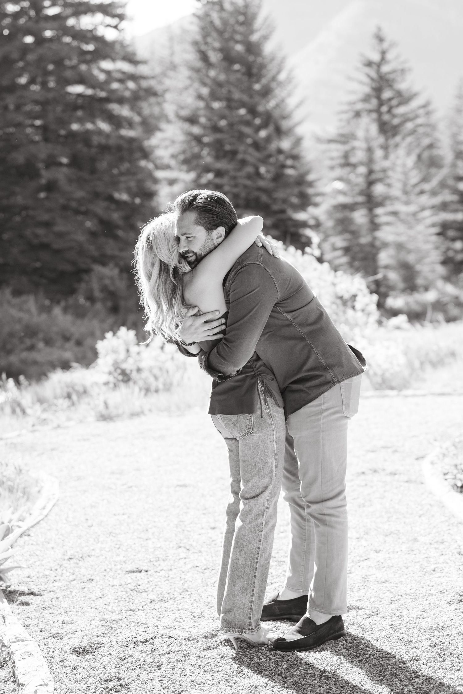 black and white - guy and girl hug after engagement