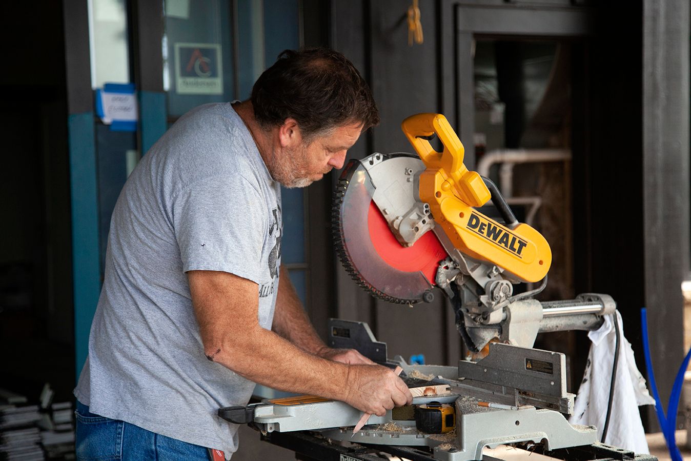 Workshop scene showing someone using power tools at a workbench with equipment.